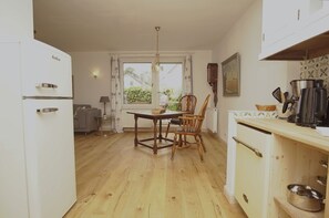 Eine Küche mit Esstisch, Stühlen, Kühlschrank und Herd.