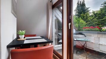 Ein Balkon mit Tisch, Stühlen und einem Blumentopf.