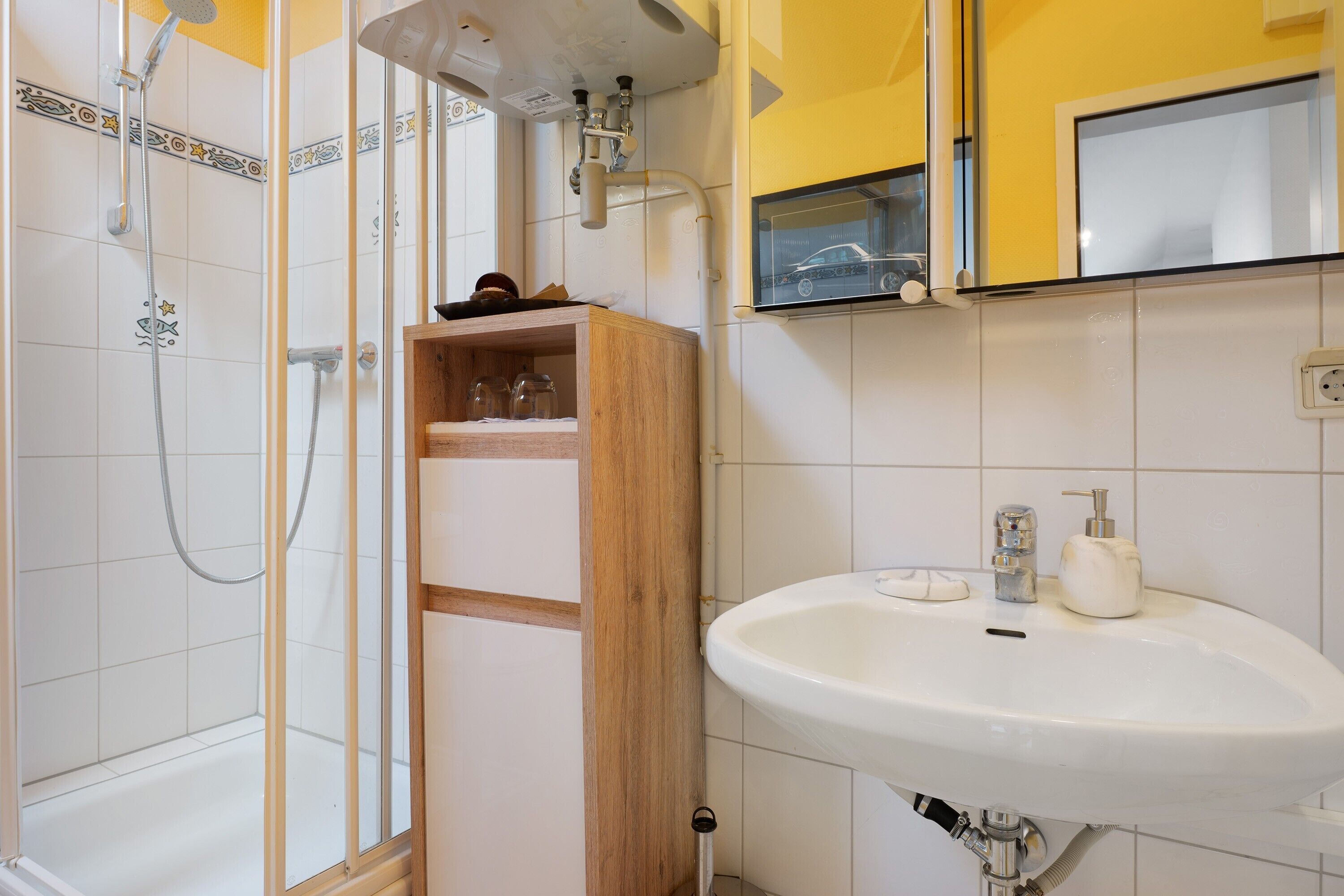 A bathroom with a shower, a sink, and a mirror.