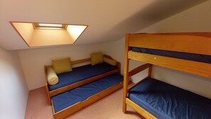 Pieni, käytännöllinen huone, jossa on kerrossängyt ja kattovalokuvio.