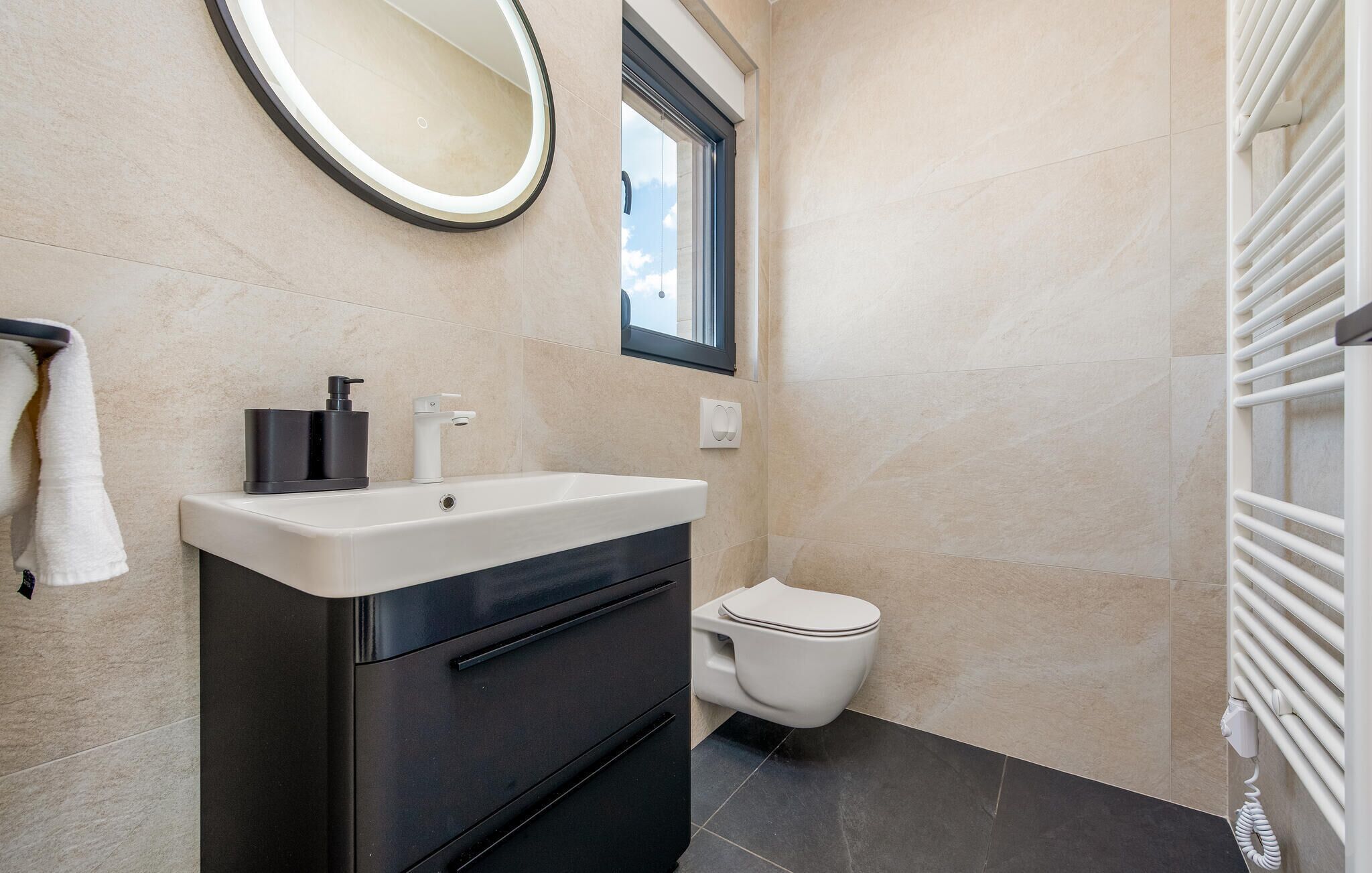 A bathroom with a sink, toilet, mirror, and towel rack.