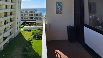 Ein Balkon mit Blick auf ein Gebäude und das Meer.