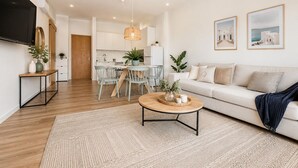 En moderne stue med sofa, sofabord og spiseområde.