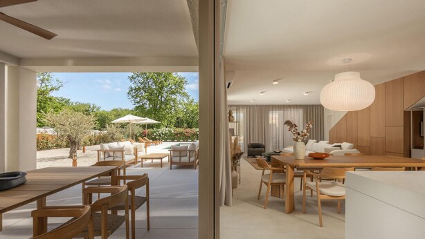 Un interno moderno con zona pranzo, cucina e vista sul giardino.