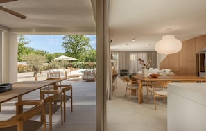 A modern interior with a dining area, kitchen, and a view of the garden. - Stunning home in Snasici with sauna (Snasici)