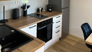 Een moderne keuken met een ingebouwde oven, een koffieapparaat en een koelkast.