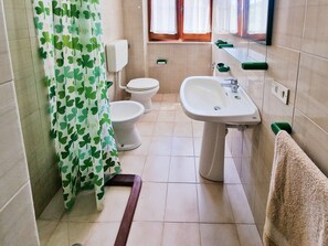 Un baño con inodoro, lavamanos y cortina de ducha.