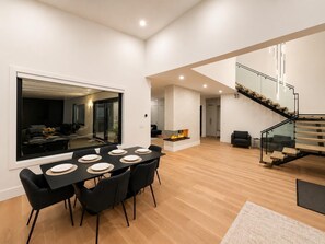 Ein zeitgemäßer Wohnraum mit Essbereich, Kamin und Treppe.