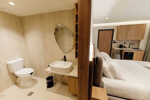 A modern bathroom with a toilet, sink, and mirror. - Aetheria North (Amaliada)