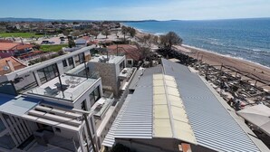 Un hotel costero con arquitectura moderna, una terraza en la azotea y vistas a la playa.