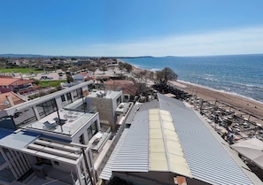 Un hotel costero con arquitectura moderna, una terraza en la azotea y vistas a la playa.