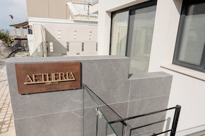 A building with a sign reading 'AETHERIA SOUTH' on a stone facade.
