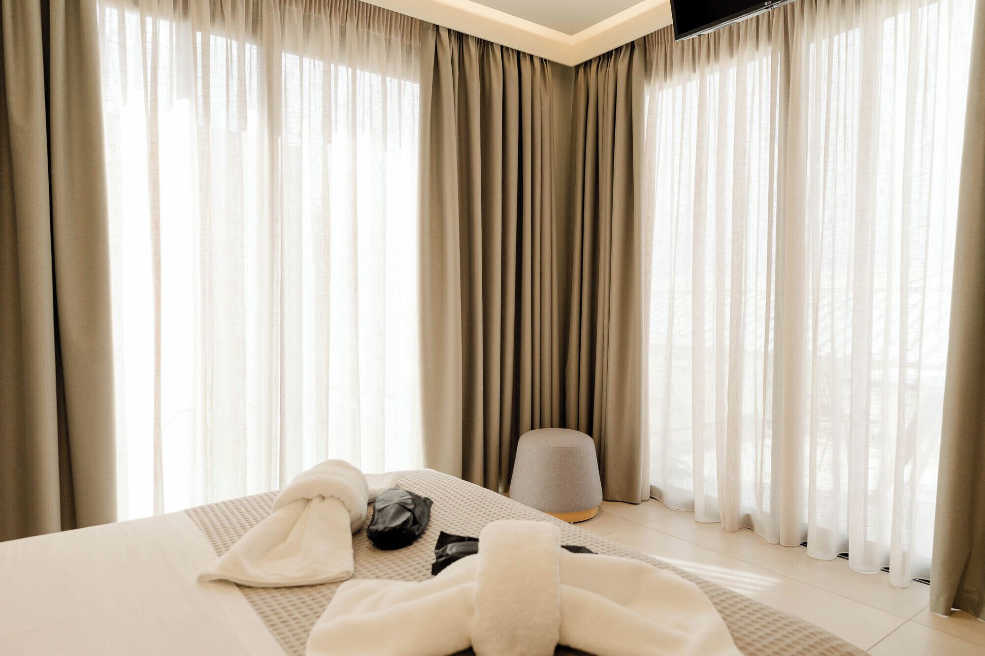 Una habitación de hotel con una cama, una silla y un televisor de pantalla plana.