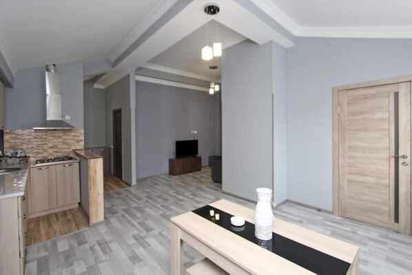 A modern kitchen with a gas stove, wooden cabinets, and a black countertop.