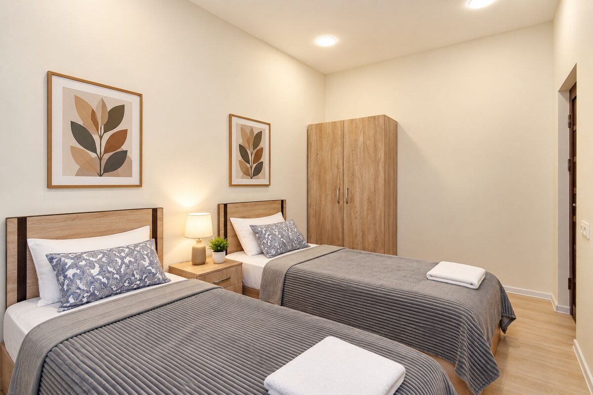 Habitación de hotel con dos camas, un armario y obras de arte en las paredes.