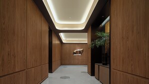 Um interior moderno com lambris de madeira, iluminação embutida e uma planta central.