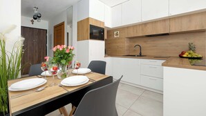 A modern kitchen with white cabinets, a wooden countertop, and a built-in oven. - Comfortable Studio with a Terrace | Near the Beach (Międzywodzie)