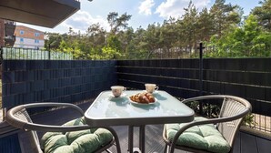 A balcony with a table, chairs, and a croissant. - Comfortable Studio with a Terrace | Near the Beach (Międzywodzie)