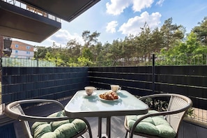 A balcony with a table, chairs, and a croissant. - Comfortable Studio with a Terrace | Near the Beach (Międzywodzie)