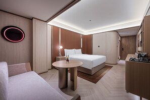 A modern hotel room with a bed, a round table, a desk, and a mirror. - Crystal Hotel Wusi Square Wheat Island (Qingdao)