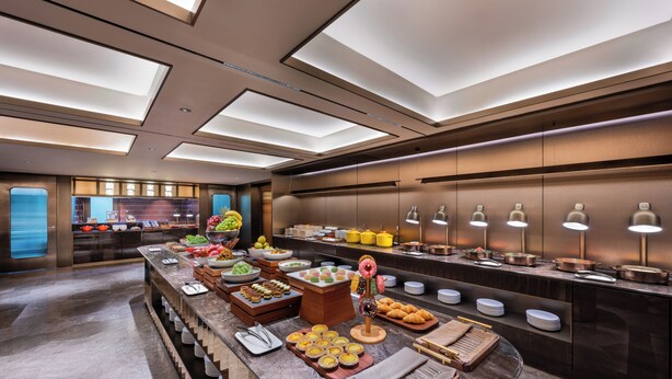 A buffet with various food items and a decorative centerpiece.