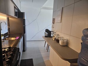 Et moderne køkken med komfur, vask og bordplade.