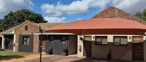 A building with a red roof, brick walls, and a paved driveway.