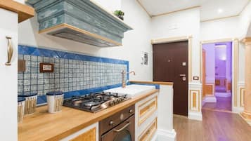 A compact kitchen with a stove, oven, and a blue-tiled backsplash.