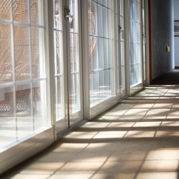 A corridor with large windows and a tiled floor. - Yugashima Golf Club & Hotel Resort (Izu)