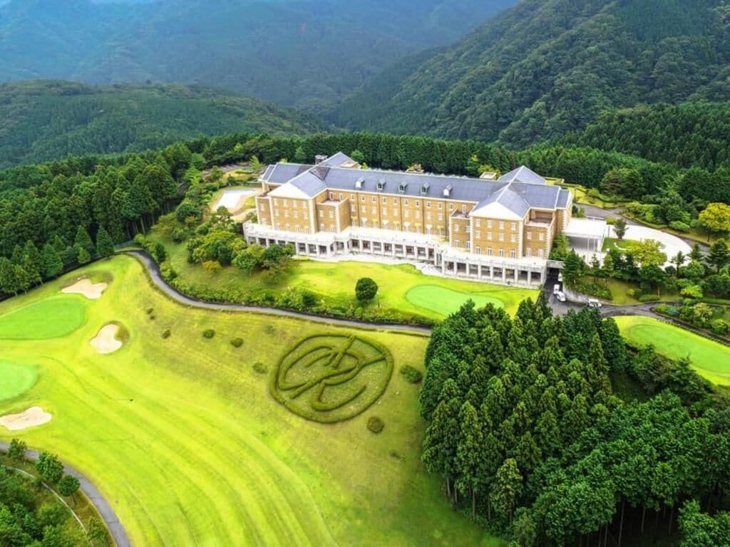 A large, multi-story hotel with a golf course in the foreground.