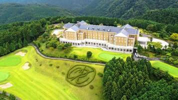 A large, multi-story hotel with a golf course in the foreground.