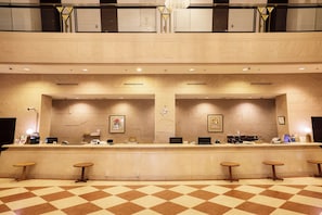 A hotel reception area with a check-in counter, two seating areas, and a check-in desk. - Yugashima Golf Club & Hotel Resort (Izu)