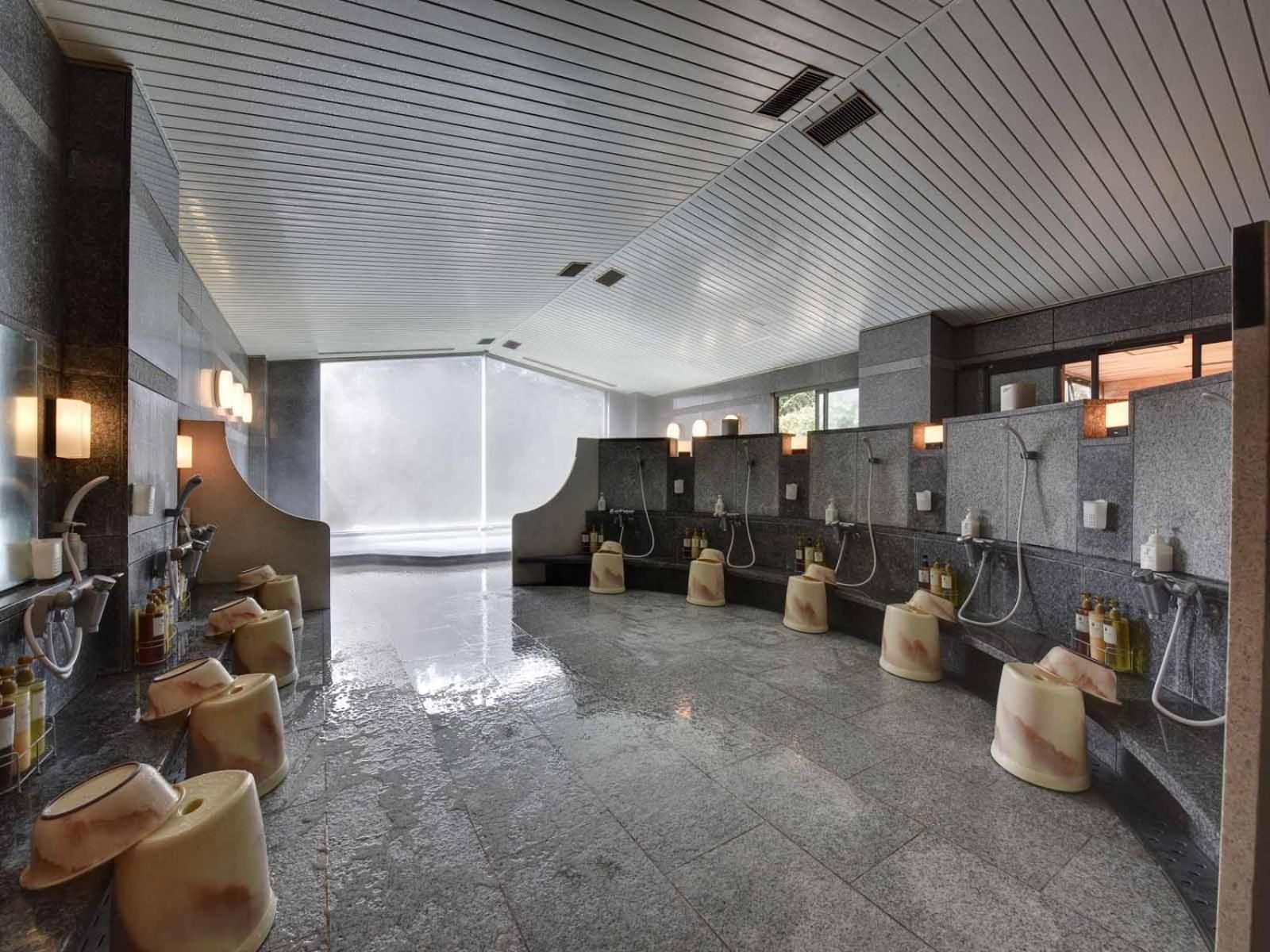 A modern bathroom with multiple sinks, a wet floor, and a large window.