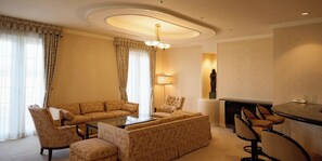 A living room with a sofa set, armchairs, a coffee table, a fireplace, and a dining area with chairs.