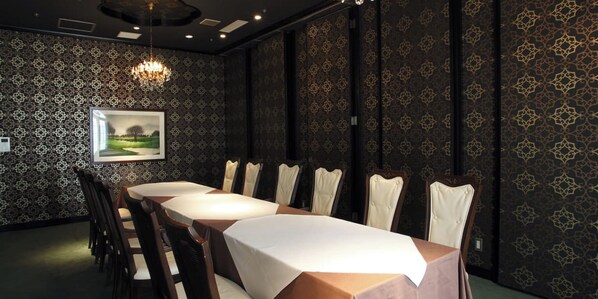 A conference room with a long table, chairs, and a chandelier.