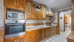 A kitchen with wooden cabinets, a Bosch oven, and a sink. - Charming House in Vejer de la Frontera, Cádiz (Vejer de la Frontera)