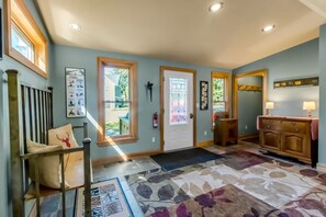 A hallway with a wooden bench, a door with a glass panel, a fireplace, and a patterned rug. - Spacious Ellicottville Chalet .2 Miles or 5 minute walk to the village. The sidewalk is right in front of the house. (Ellicottville)