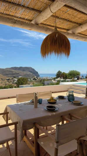 Ein Tisch im Freien mit Blick auf das Meer und die Berge.