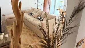 An arched doorway leading to a living room with a sofa, a ceiling fan, and a vase with dried plants. - Mediterranean-style house in Cabo de Gata (Almeria)