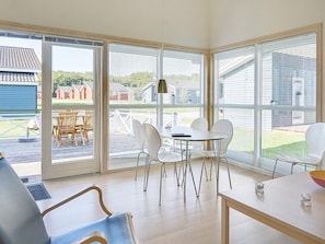 Un interior moderno con comedor, ventanas amplias y vistas al exterior.