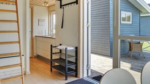 Una cocina moderna con una escalera de madera, un tendedero y vistas al exterior a través de un gran ventanal corredero.
