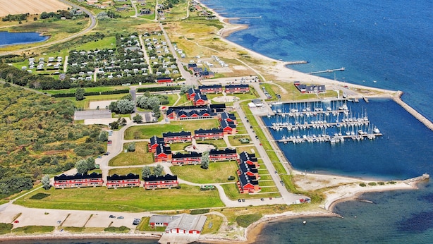 An aerial view of a coastal area with a marina, residential buildings, and a beach. - Lemvig Coastal Stay (Lemvig)