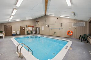 En inomhuspool med en livboj, en takfläkt och en dörr.