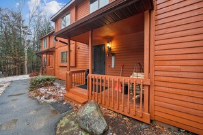 Eine Holzhütte mit einer Veranda, einer Tür und einer kleinen Stufe zum Eingang.