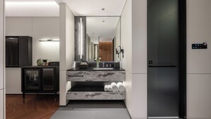 Cozinha moderna com bancada de mármore, forno embutido e geladeira preta.