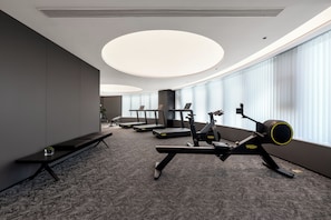 Ein Fitnessraum mit Laufbändern, einem Ergometer und einem Rudergerät.