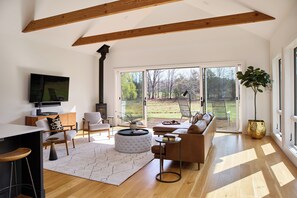 Un salon moderne avec une cheminée, un canapé, une table basse et un téléviseur fixé au mur.
