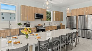 Una cocina moderna con una isla central, electrodomésticos de acero inoxidable y armarios de madera.