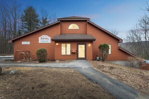 A brown building with a sign that reads 'The Summit' and 'Rentals at The Summit Community Center.' - Adirondack Retreat | Heated Pool + Game Room with Billards + Foosball | Cloud (North Creek)