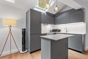 A modern kitchen with grey cabinetry, a central island, and pendant lighting. - VOLCANIC HOT TUB EXPERIENCE Central London 2BR Lagoon, Memories Await for 6 (Greater London)